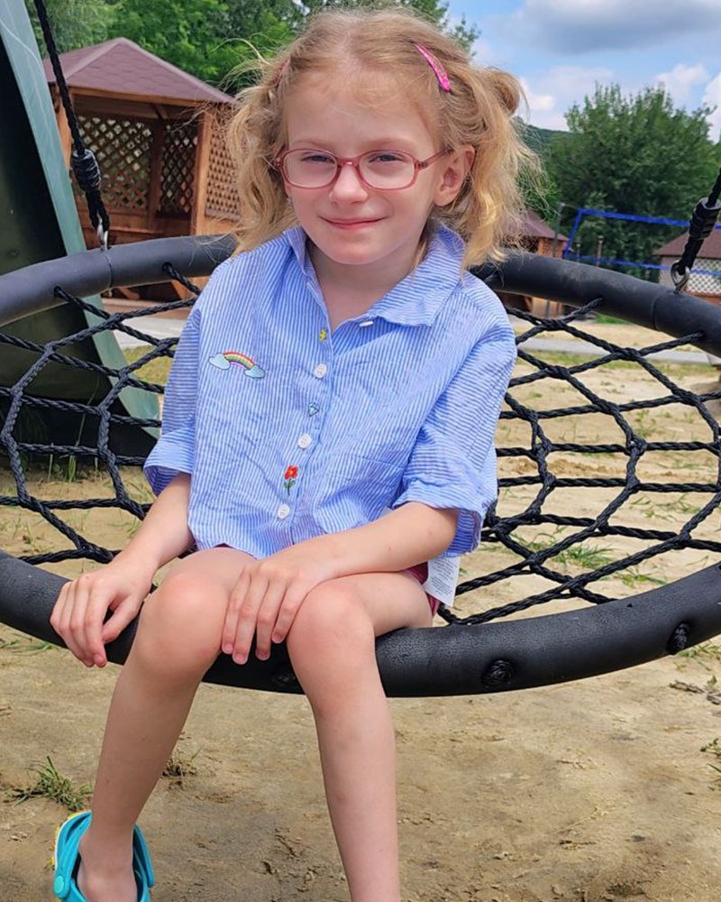 Ariana sitting on a nest swing outdoors