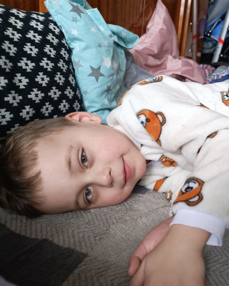 Damir smiling, resting on a pillow at home