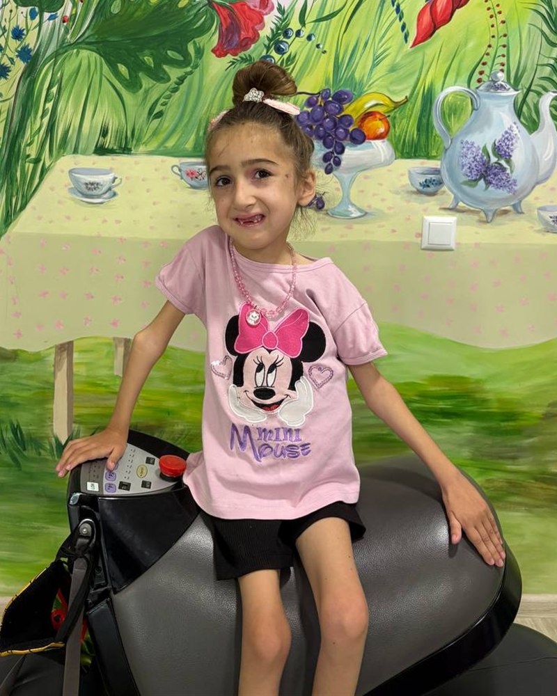 Sofia sitting on a therapy simulator