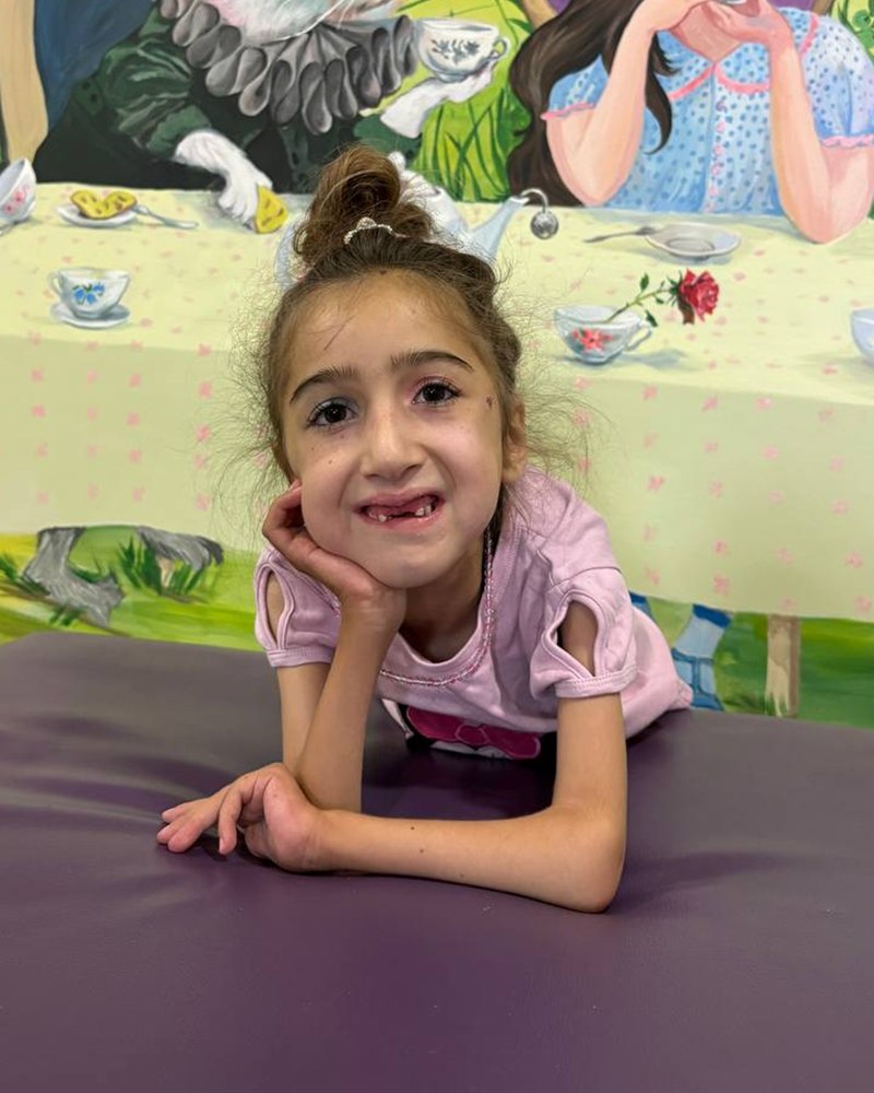 Sofia smiling, resting her chin on her hand
